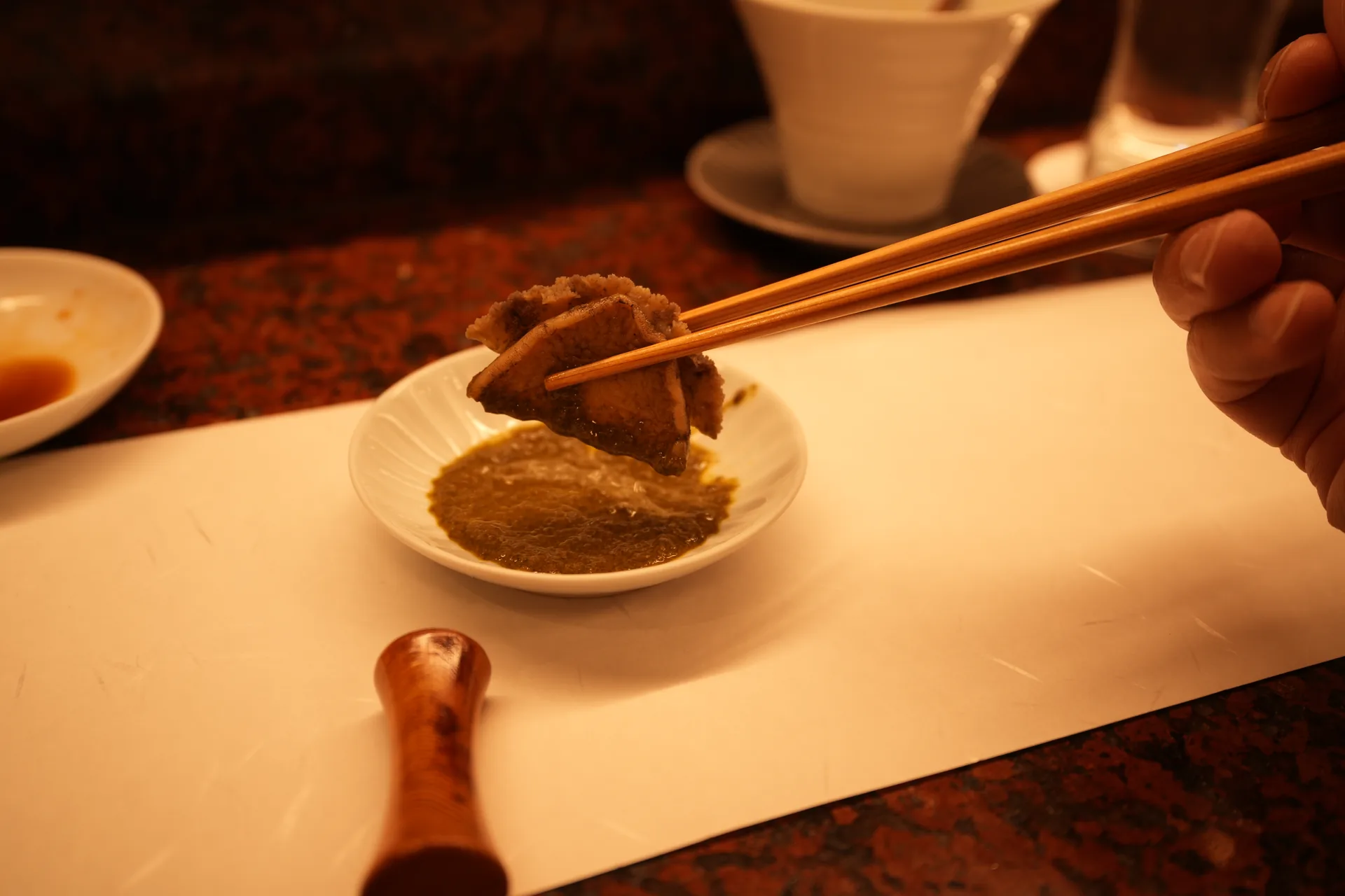 木の箸で料理をつまむ手元