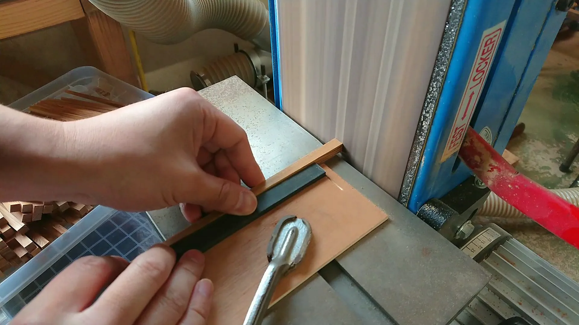 箸材を研磨面に当ててヤスリがけする手元